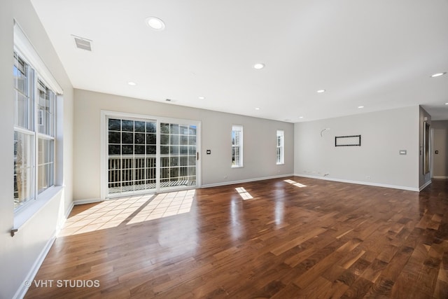 unfurnished living room featuring recessed lighting, baseboards, and wood finished floors