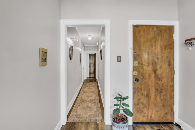 hallway featuring baseboards and wood finished floors