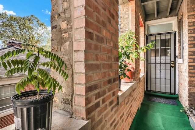 entrance to property featuring brick siding