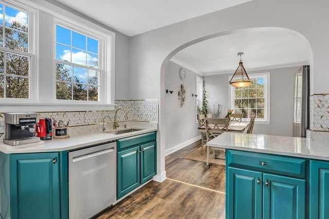 kitchen with dishwasher, light countertops, arched walkways, and a sink