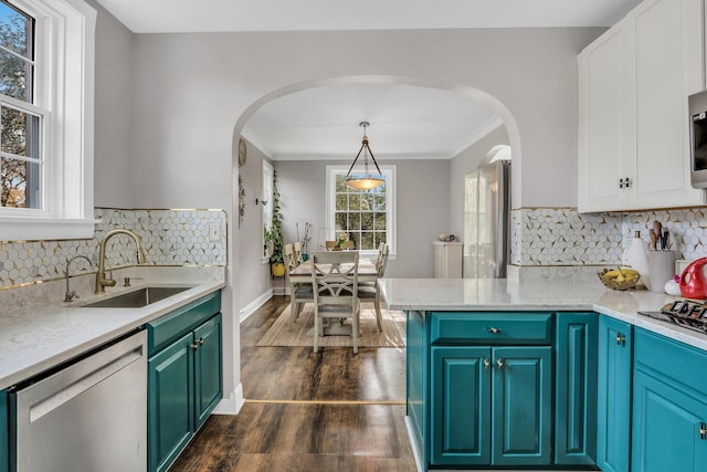 kitchen with white cabinets, appliances with stainless steel finishes, arched walkways, and a sink