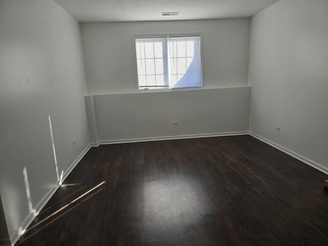 unfurnished room with visible vents, hardwood / wood-style flooring, and baseboards