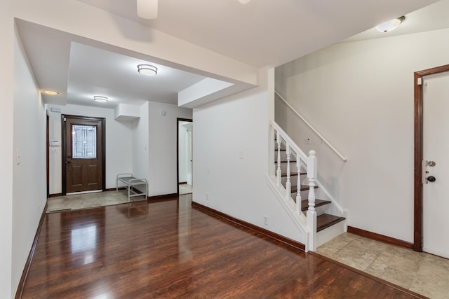 foyer featuring stairway, baseboards, and wood finished floors