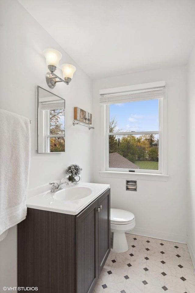 bathroom with toilet, tile patterned floors, vanity, and baseboards