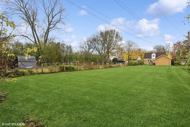 view of yard with an outbuilding and fence