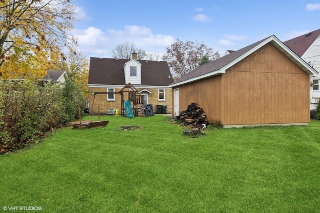 back of property with a chimney, a playground, and a yard