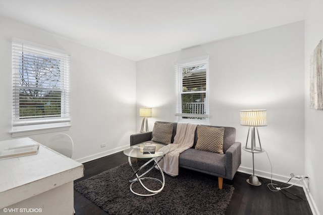 living area featuring baseboards and wood finished floors