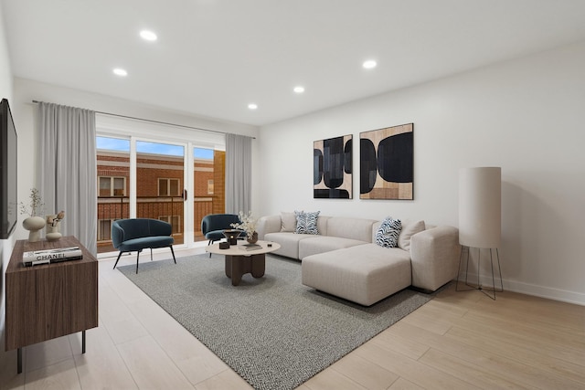 living room featuring recessed lighting, light wood-style floors, and baseboards