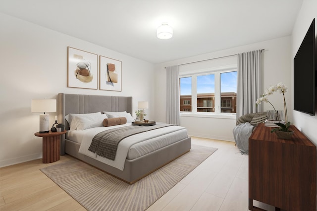 bedroom with light wood-style floors and baseboards