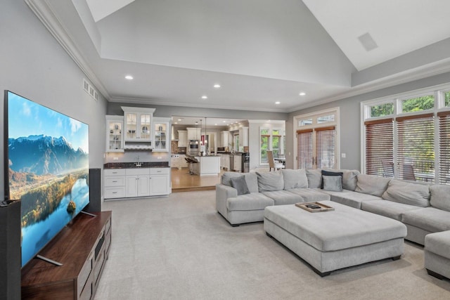 living room featuring high vaulted ceiling, ornamental molding, plenty of natural light, and visible vents