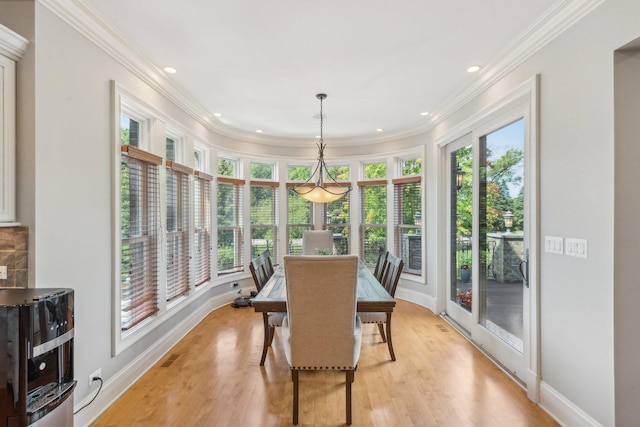 dining room featuring light wood-style floors, a healthy amount of sunlight, and ornamental molding