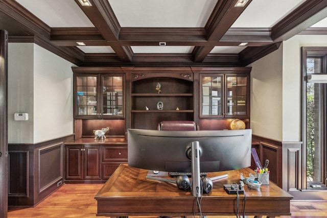 office with light wood finished floors, coffered ceiling, beam ceiling, and a healthy amount of sunlight