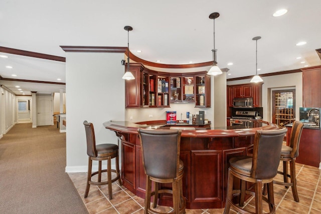 bar featuring light colored carpet, recessed lighting, ornamental molding, appliances with stainless steel finishes, and pendant lighting