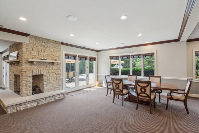 carpeted dining room with crown molding, recessed lighting, a fireplace, and baseboards