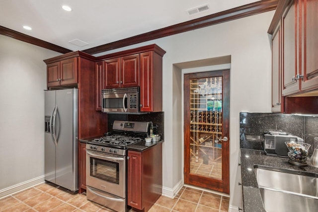 kitchen with light tile patterned floors, visible vents, backsplash, appliances with stainless steel finishes, and dark brown cabinets