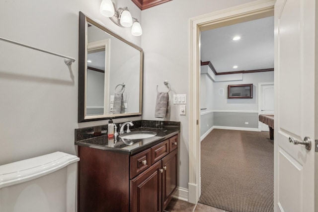 bathroom with toilet, recessed lighting, vanity, baseboards, and ornamental molding