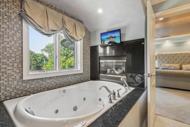 bathroom featuring tile patterned floors, a tub with jets, and ensuite bathroom