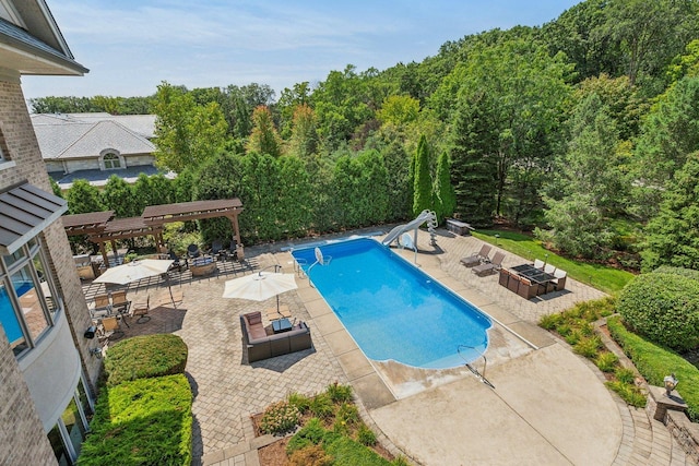 outdoor pool with a fire pit, a water slide, a patio area, and a pergola