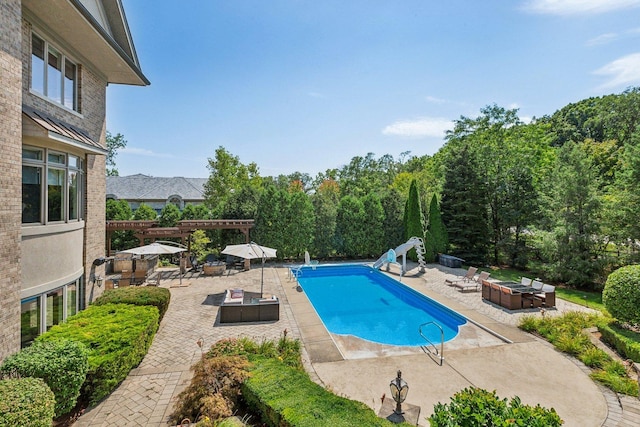 pool featuring an outdoor fire pit, a water slide, and a patio area