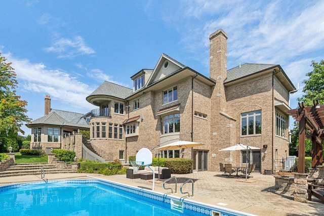 back of property with a patio area, stairs, a chimney, and brick siding