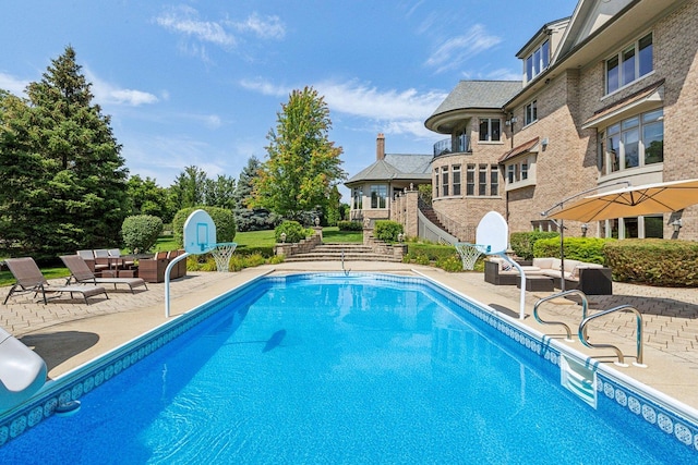 pool featuring a patio area, outdoor lounge area, and stairs