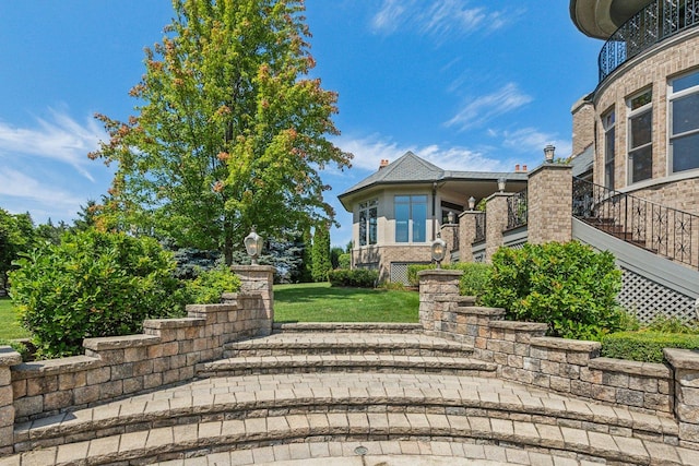 view of front facade with a front lawn and stairs