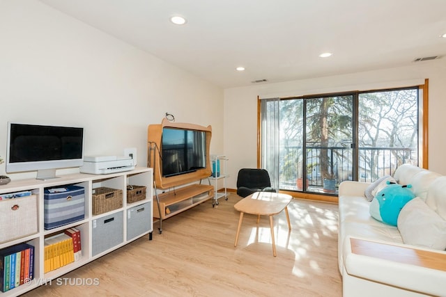 living room with recessed lighting, visible vents, and light wood-type flooring