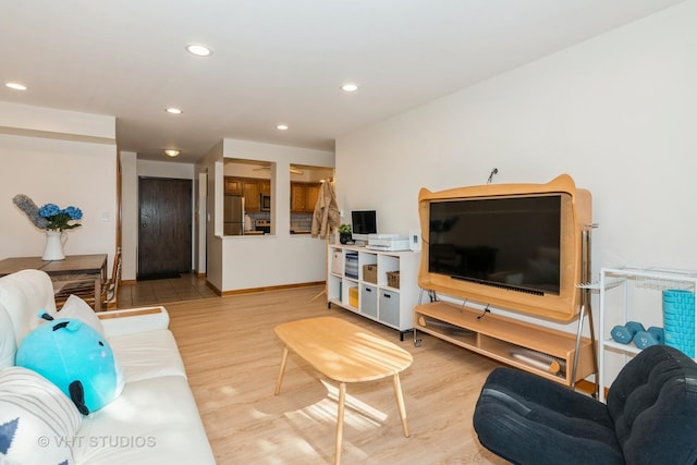 living room featuring recessed lighting, baseboards, and light wood-style flooring