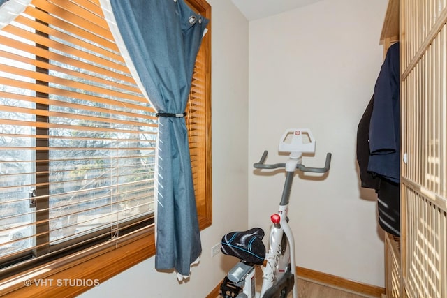 workout room featuring wood finished floors and baseboards