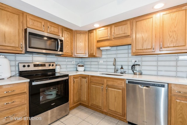 kitchen featuring a sink, light countertops, tasteful backsplash, and stainless steel appliances