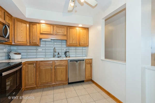 kitchen with decorative backsplash, stainless steel appliances, light countertops, and a sink