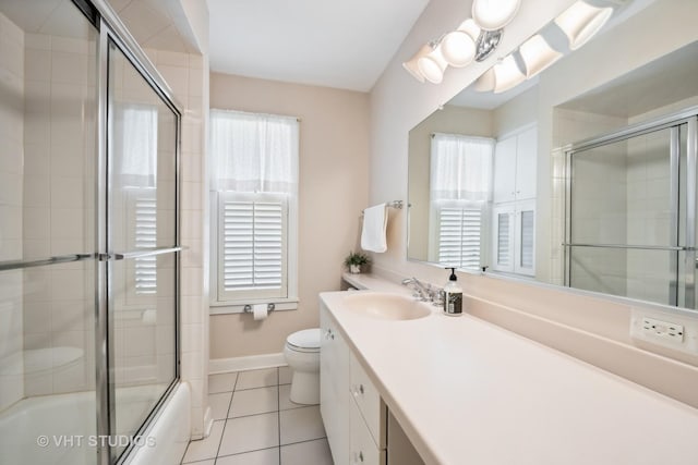 full bath with vanity, baseboards, shower / bath combination with glass door, tile patterned floors, and toilet