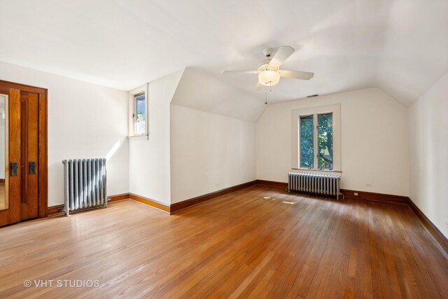 full bath featuring tile patterned floors, toilet, a bathing tub, radiator heating unit, and tile walls