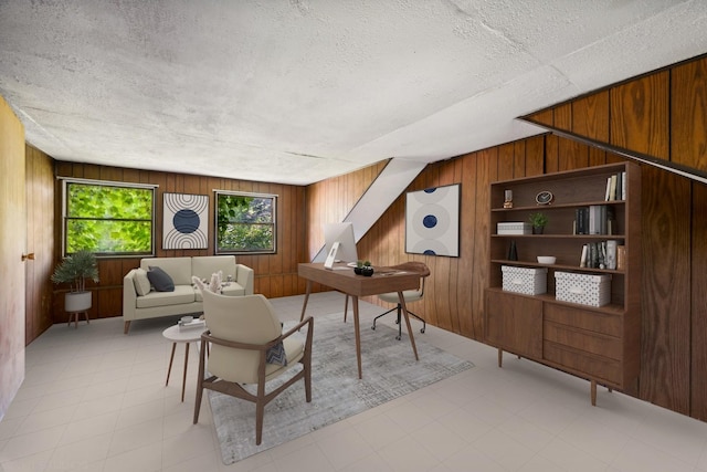 living room featuring wood walls and a textured ceiling