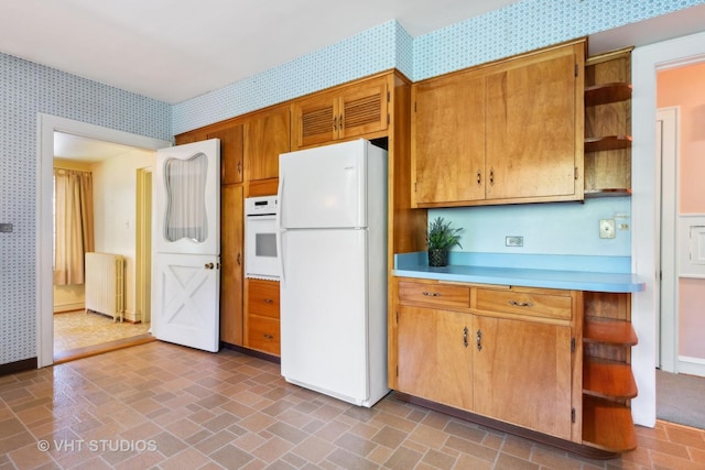 kitchen with white appliances, wallpapered walls, radiator heating unit, and open shelves