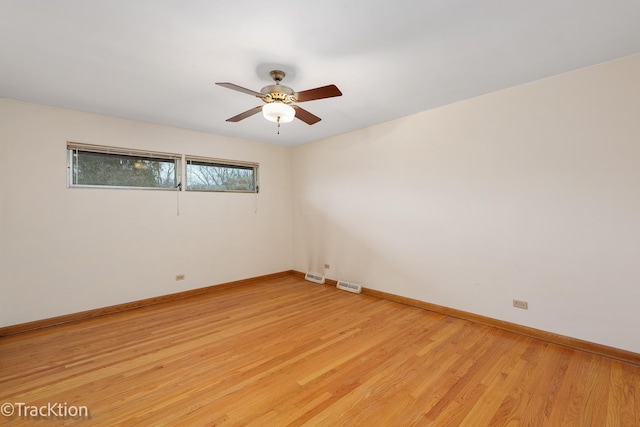 unfurnished room featuring a ceiling fan, visible vents, light wood-style flooring, and baseboards