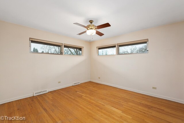 spare room featuring light wood-style flooring, visible vents, and baseboards