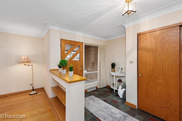 entrance foyer featuring stone finish floor, baseboards, visible vents, and ornamental molding