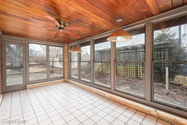 unfurnished sunroom with a ceiling fan, a wealth of natural light, and wood ceiling