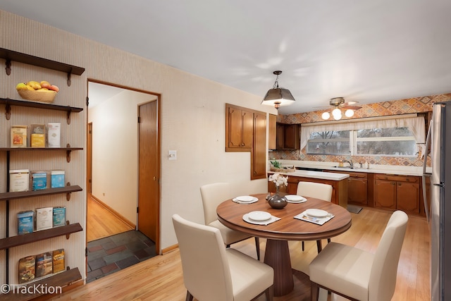 dining space featuring light wood-type flooring and ceiling fan