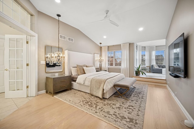 bedroom with visible vents, baseboards, wood finished floors, and vaulted ceiling