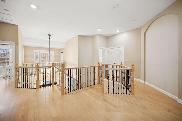 corridor with an upstairs landing, recessed lighting, baseboards, and wood finished floors