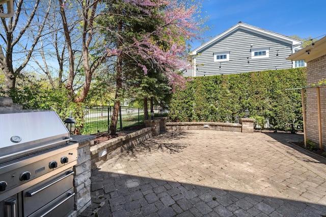 view of patio with an outdoor kitchen and fence