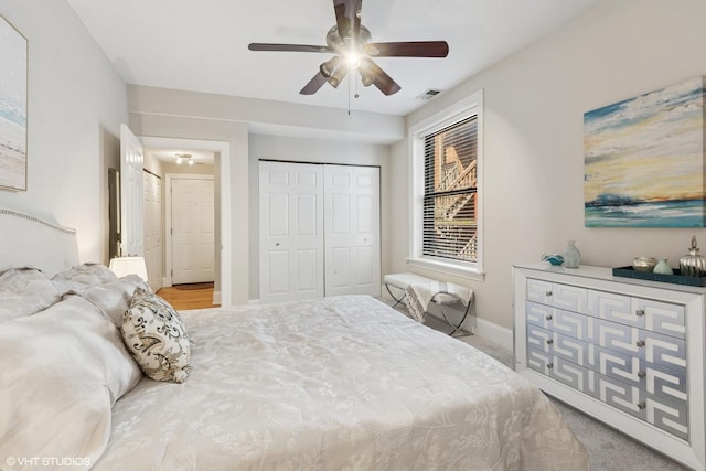 carpeted bedroom with a ceiling fan, baseboards, visible vents, and a closet