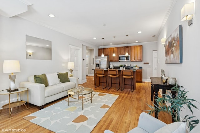 living room featuring recessed lighting, baseboards, ornamental molding, and light wood finished floors