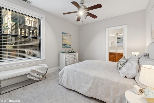 carpeted bedroom with a ceiling fan, baseboards, a sink, and ensuite bathroom