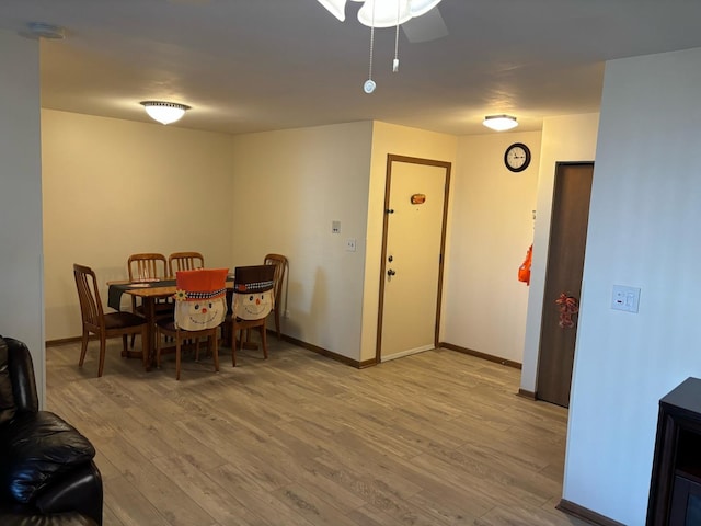 dining room with baseboards, ceiling fan, and light wood-style floors
