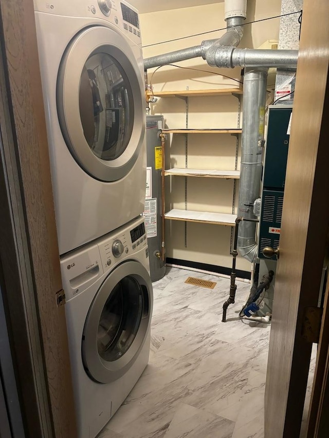 laundry room with stacked washer / dryer and water heater