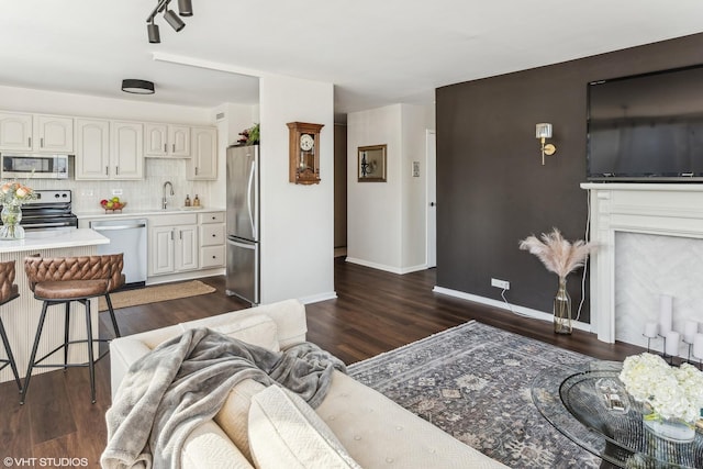 living room with baseboards and dark wood-style flooring