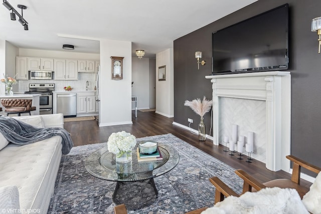 living area featuring baseboards and dark wood finished floors